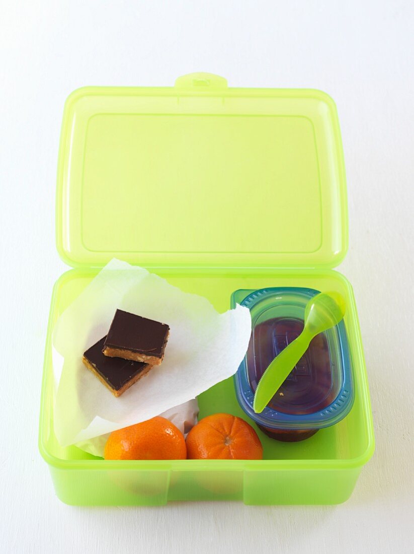 Lunchbox mit Schokoladenschnitten und Clementinen
