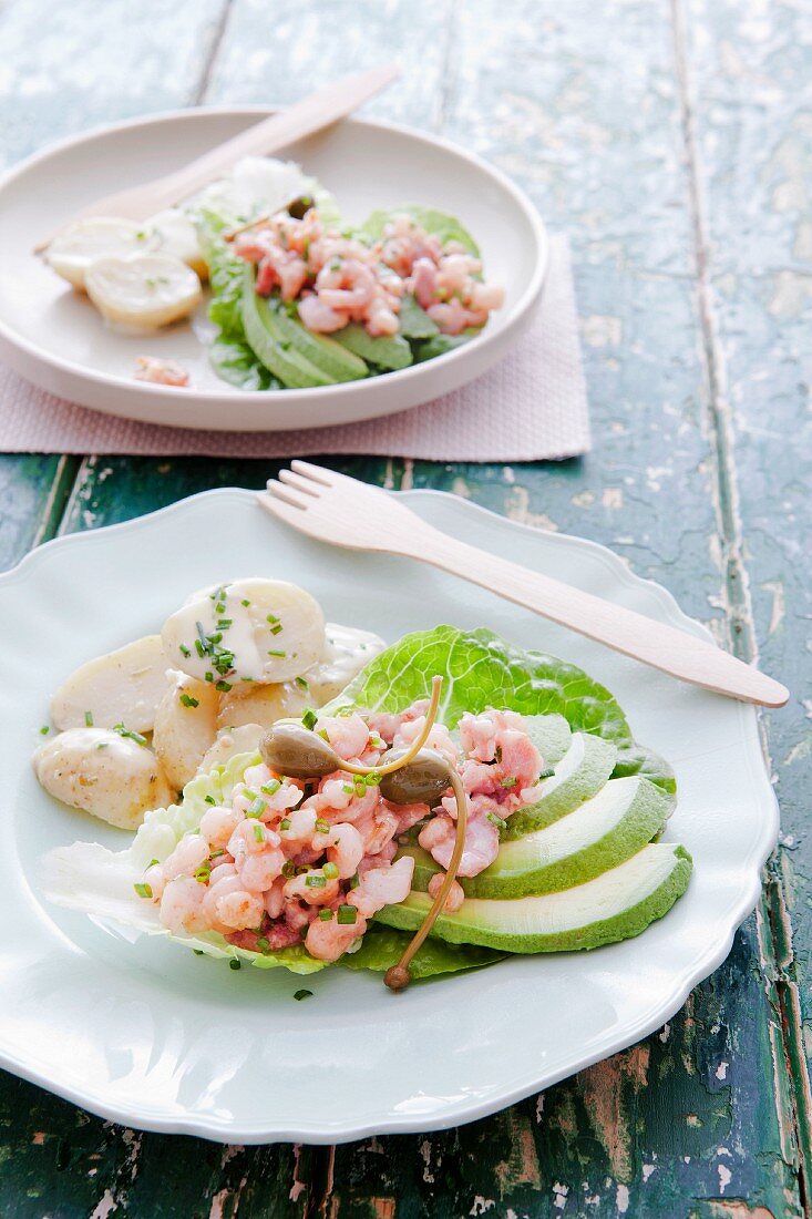 Lettuce boats filled with prawns, avocado wedges and capers