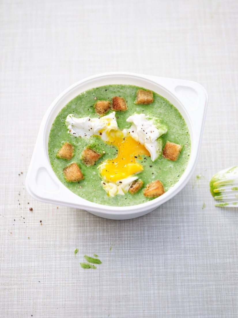 Cream of spinach soup with a poached egg and croutons