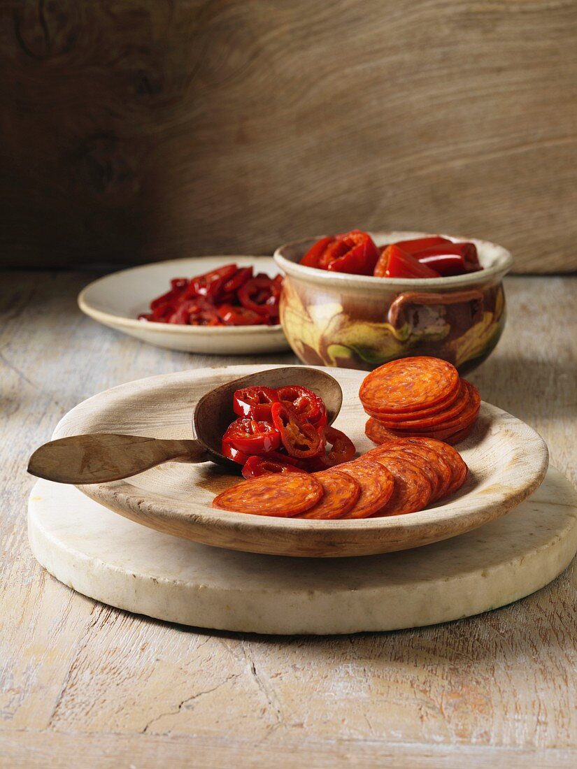 Pepperoni and chili on wooden plate