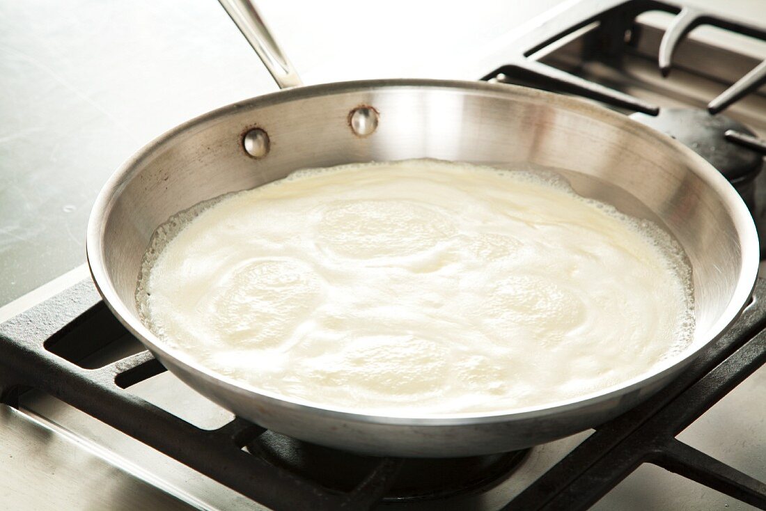 Alfredo Sauce Simmering in a Skillet