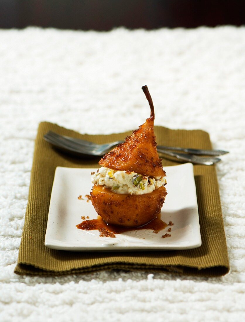 A baked pear filled with goat's cheese and pistachios
