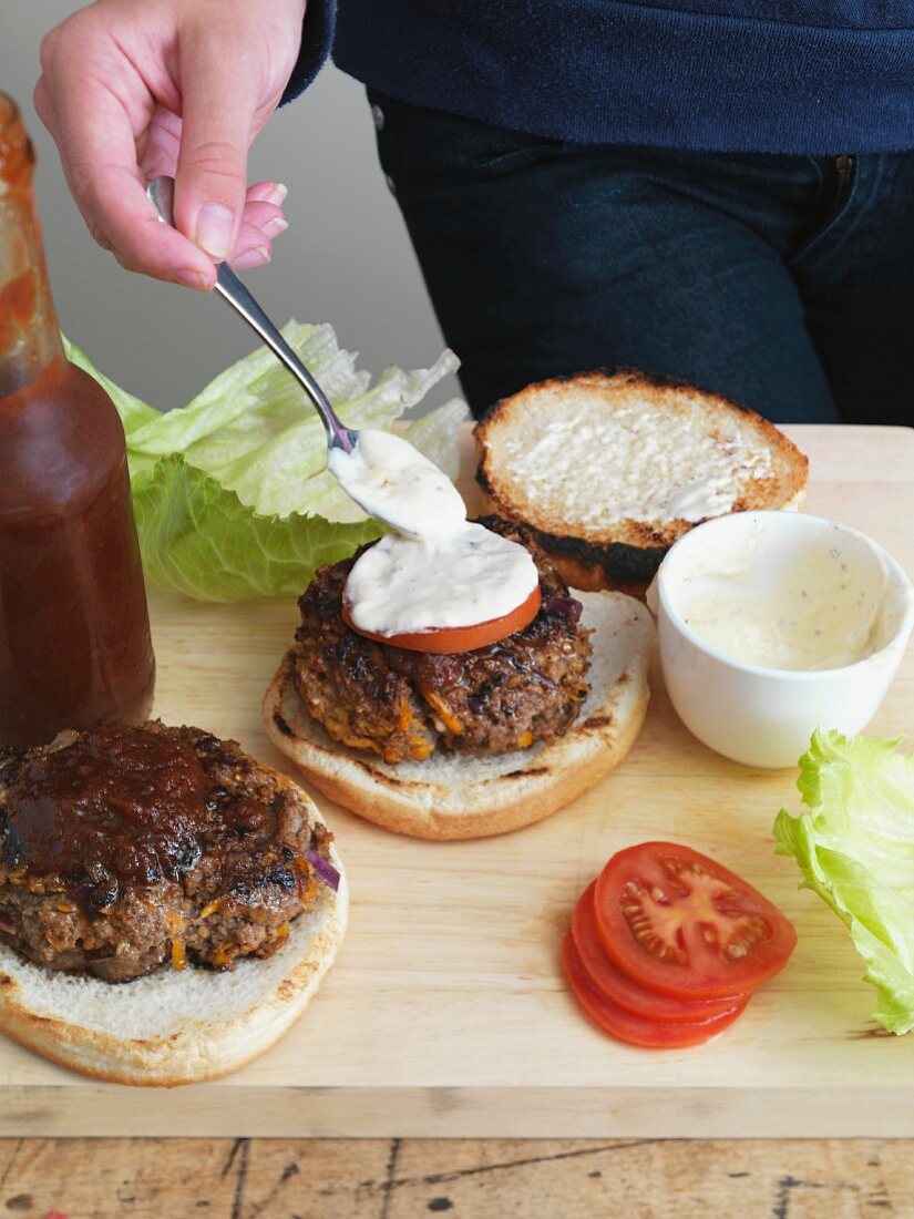 A hamburger being spread with remoulade