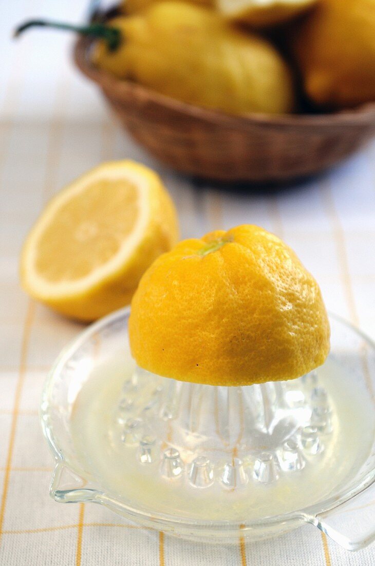 Zitronenhälfte auf Zitruspresse aus Glas