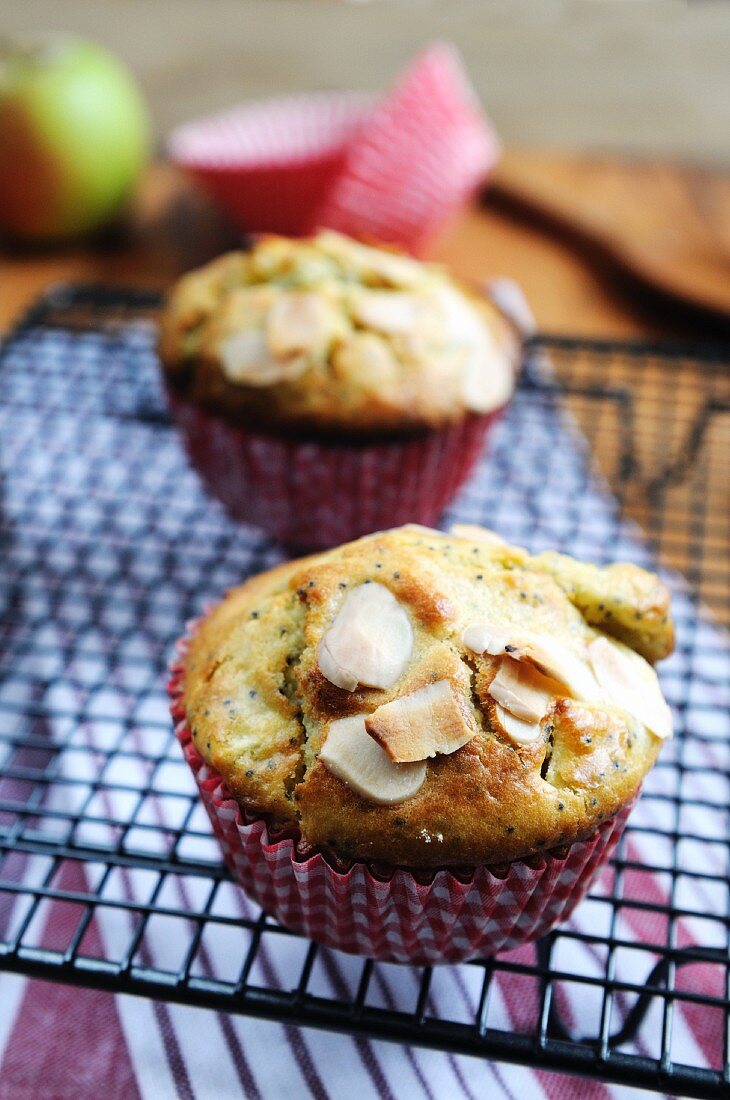 Apple muffins with poppy seeds and almonds on a wire rack
