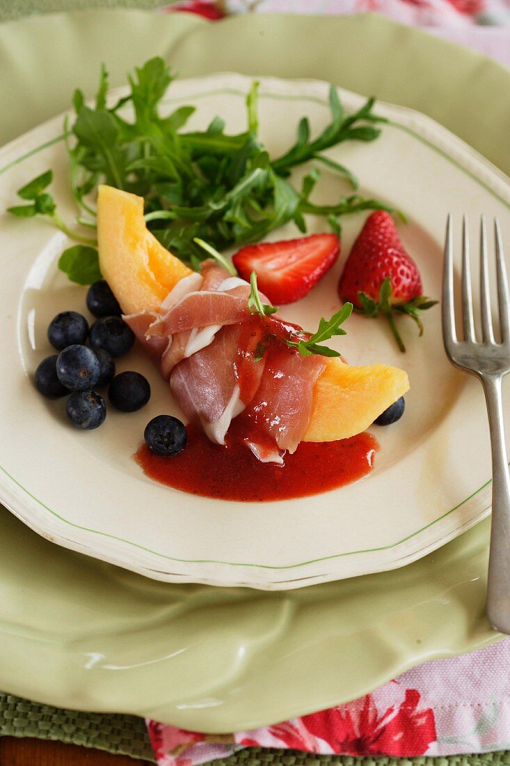 Melon salad with strawberry sauce and Prosciutto
