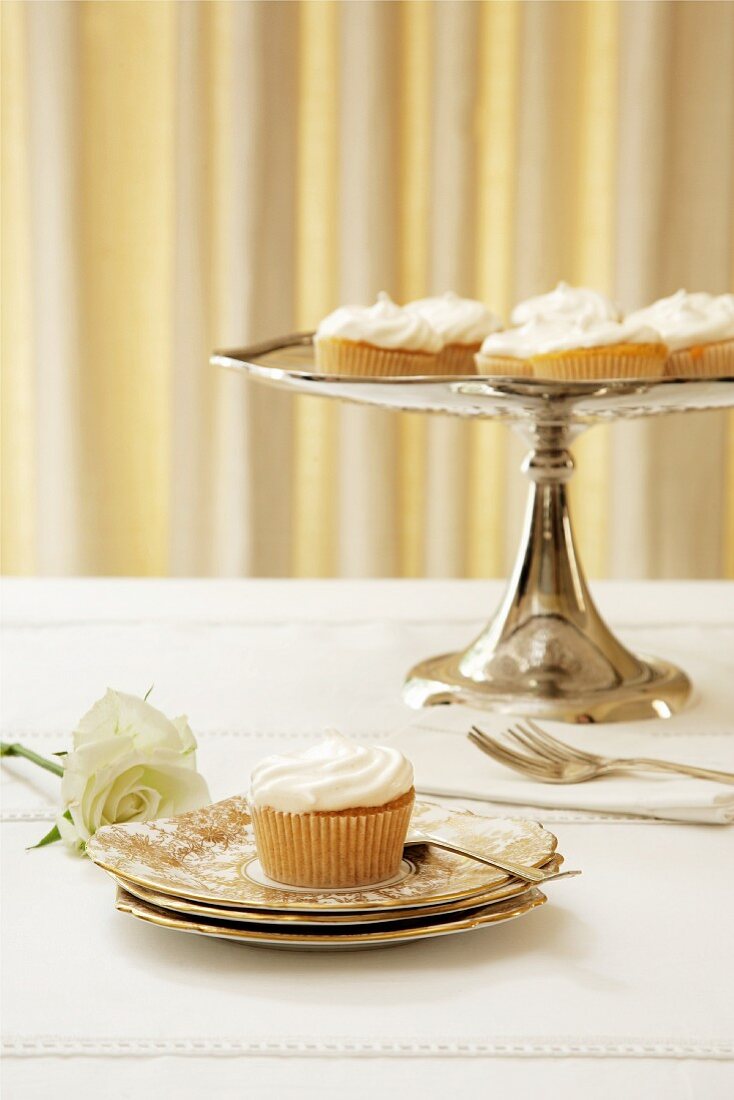 Cupcakes mit Zitronenbaiser auf Teller & Kuchenständer