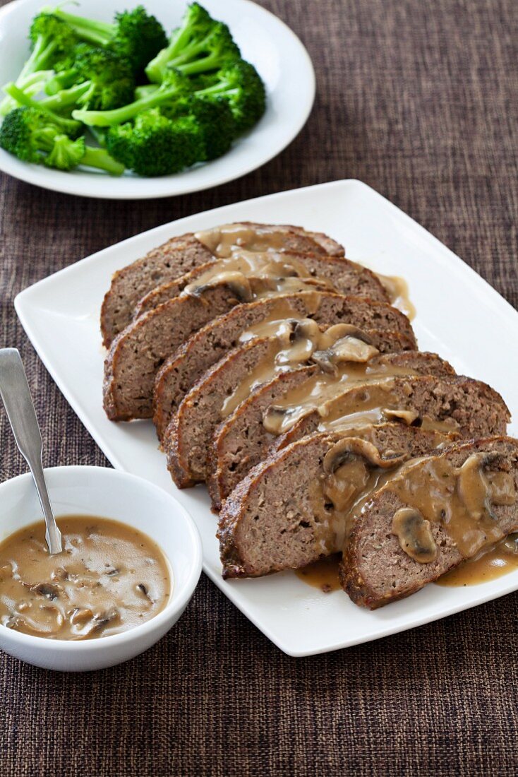 Hackbraten in Scheiben auf Servierplatte mit Pilzsauce & Brokkoli