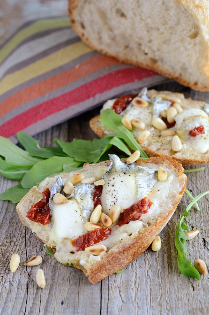 Bruschetta topped with goat's cheese, dried tomatoes and pine nuts