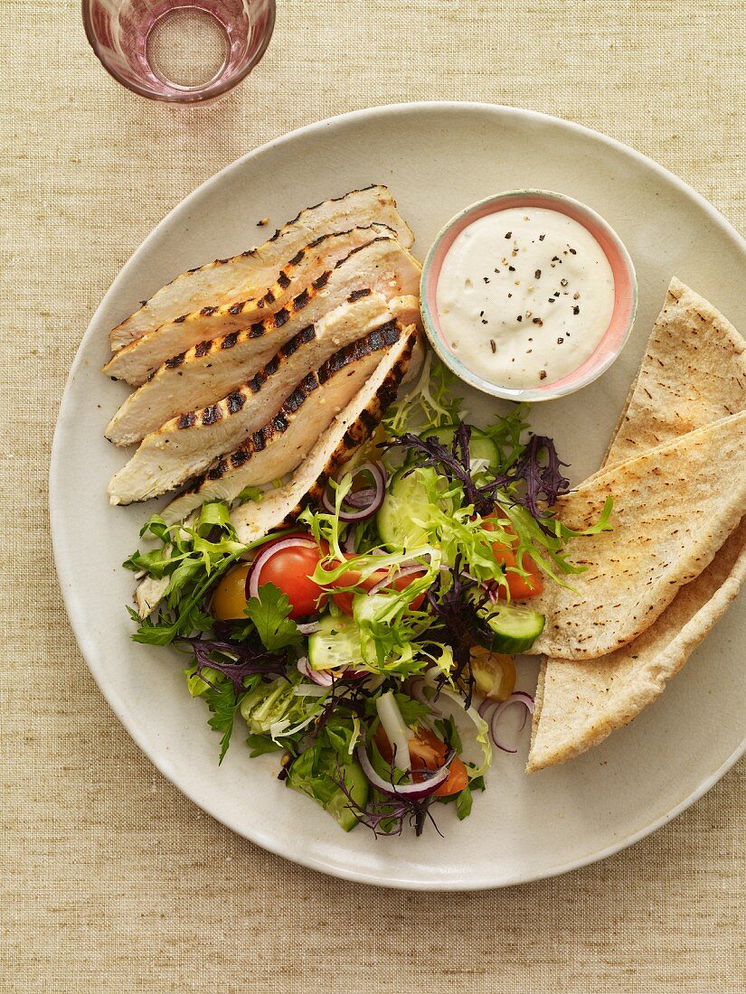 Sliced Grilled Chicken with Salad, Pita Bread and a Bowl of Dressing