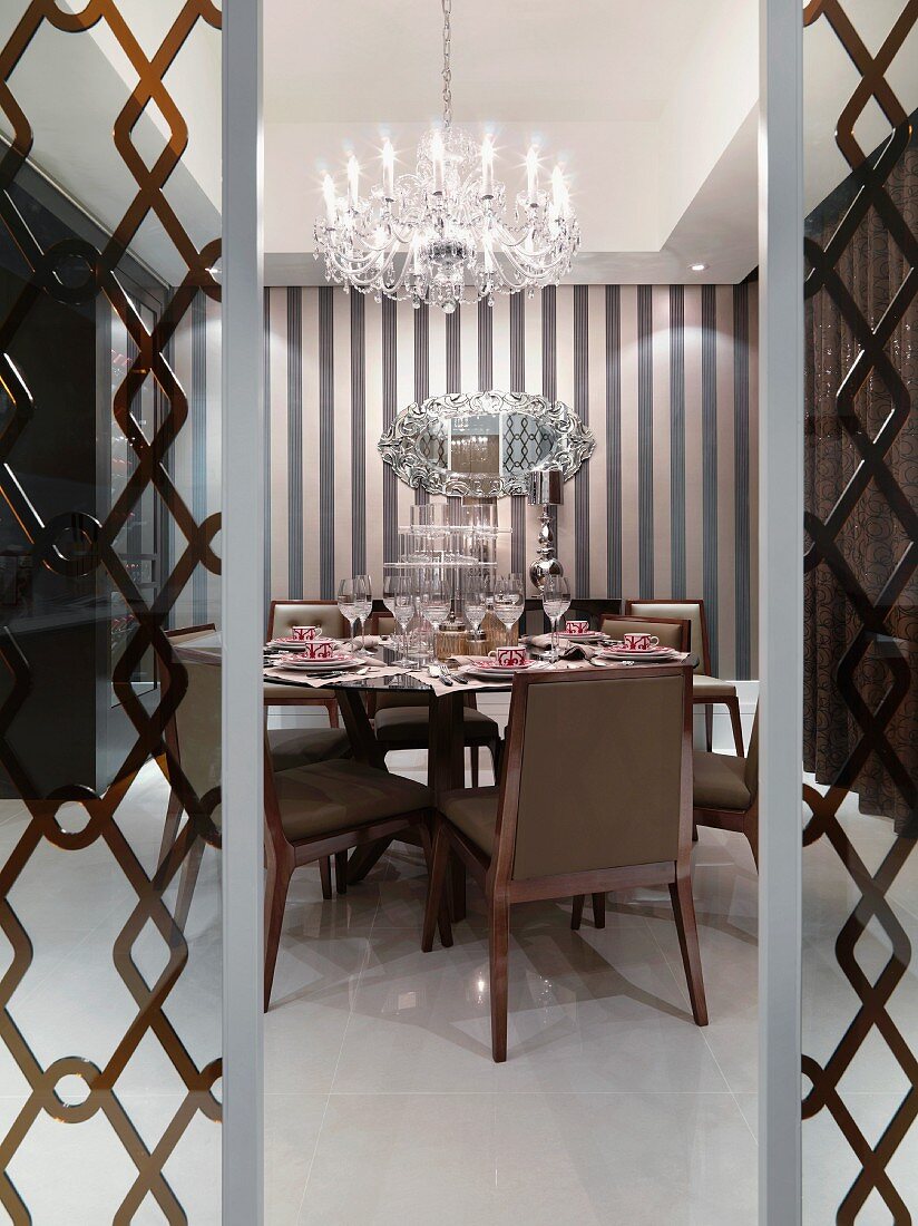 Elegant dining room with chandelier and printed wall paper
