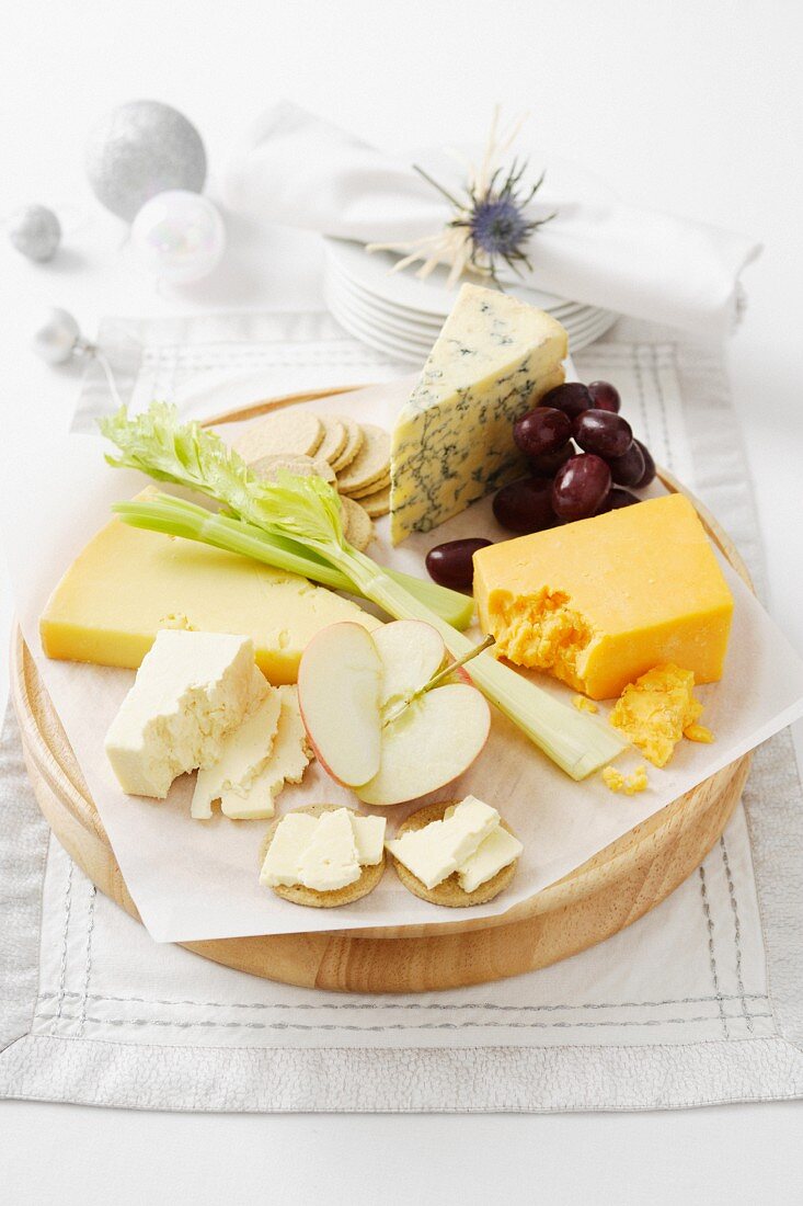Cheese and fruit on wooden board