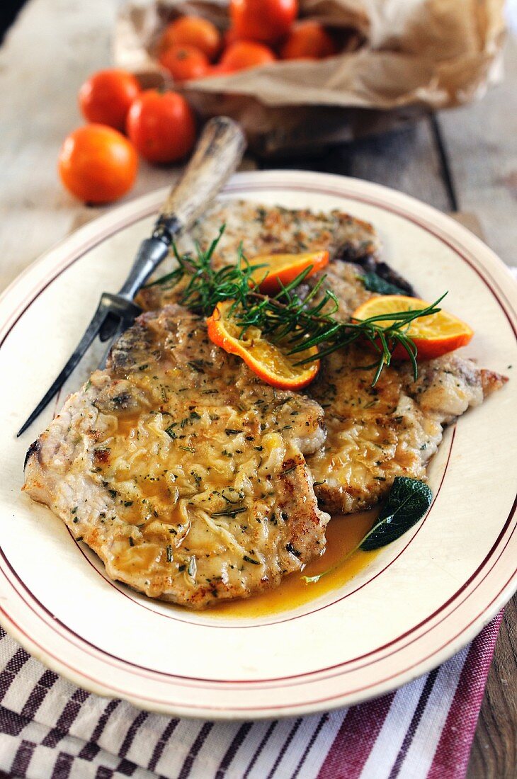 Breaded pork chops with an orange and rosemary sauce