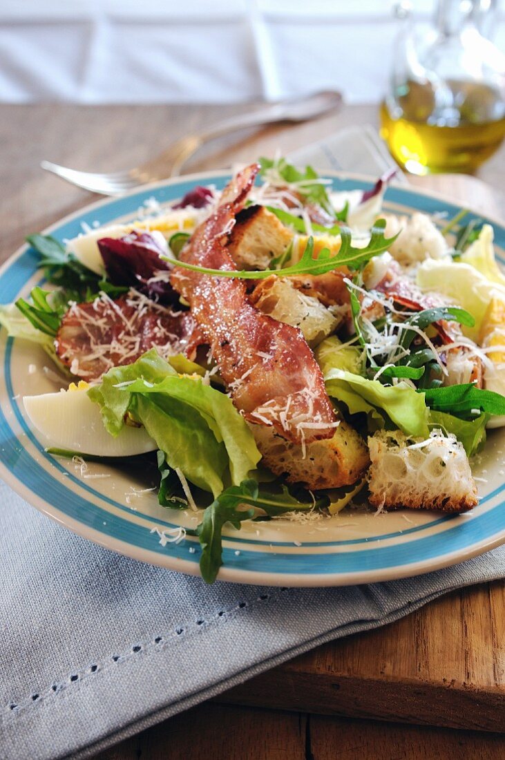 Salat mit Pancetta, gekochtem Ei, Parmesan und Croûtons