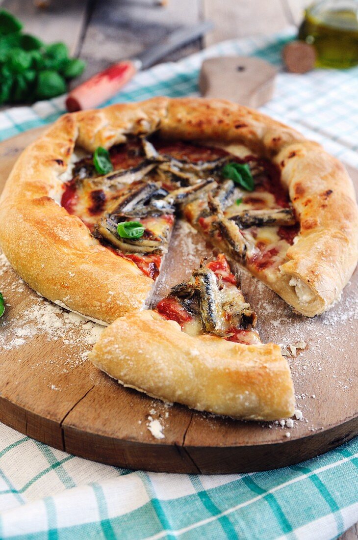 Pizza mit gefülltem Rand mit Sardellen, Tomaten und Mozzarella