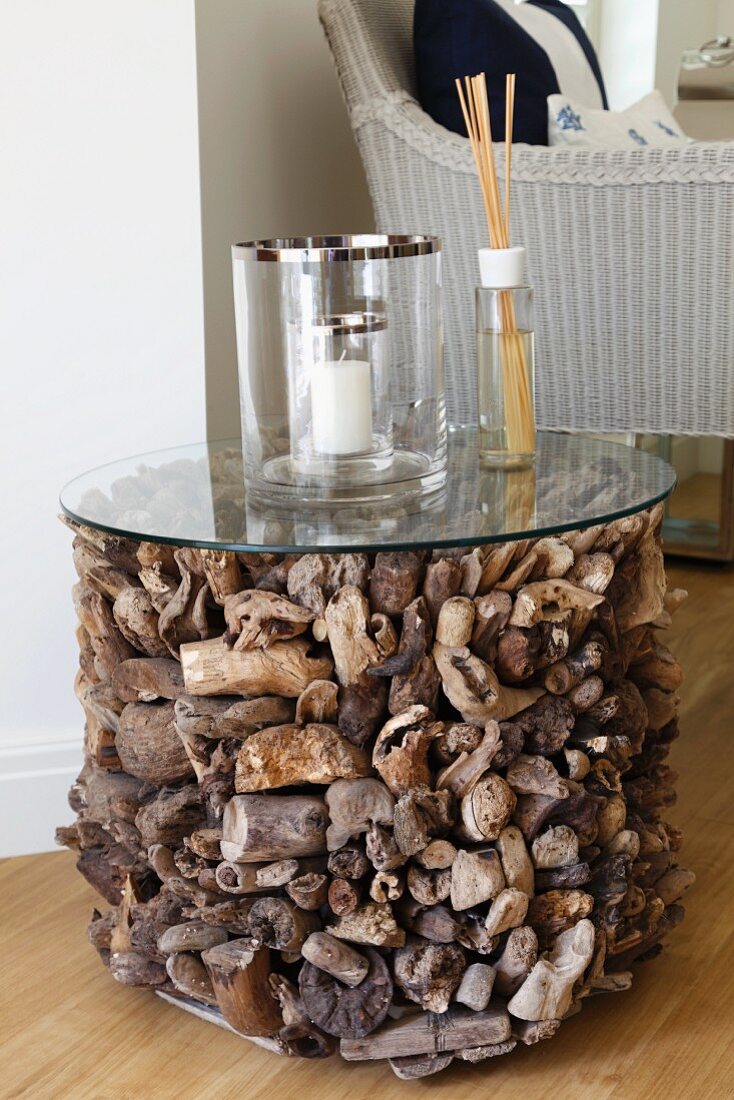 Cylinder of variously shaped driftwood pieces with glass top as unusual side table