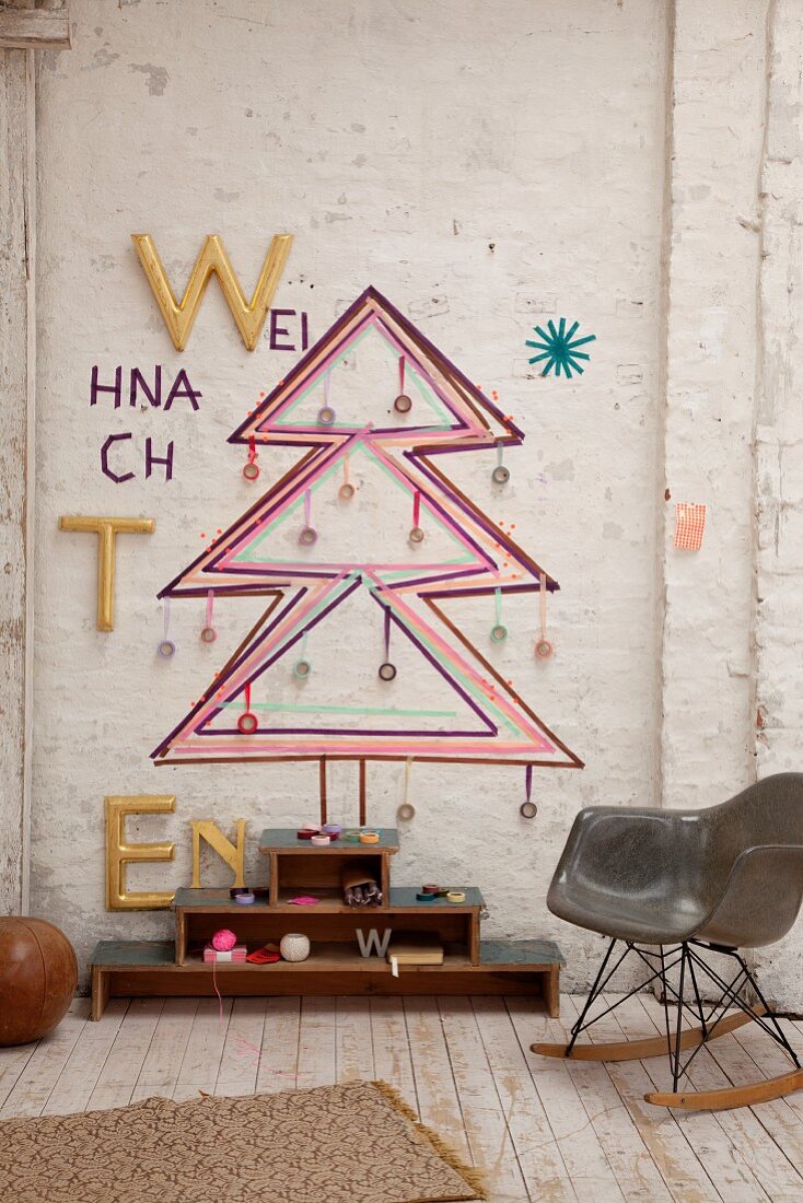 Bauhaus rocking chair in front of Christmas tree sketched on wall in rustic interior