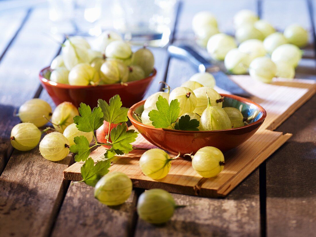 Green gooseberries in bowls and next to them