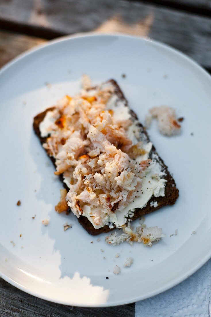 A slice of bread topped with cream cheese and crab meat
