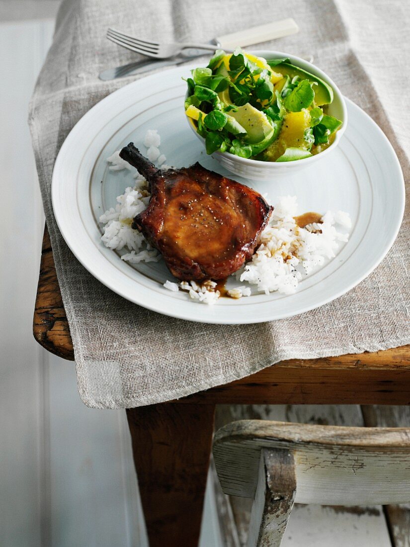 Plate of pork chop, rice and salad