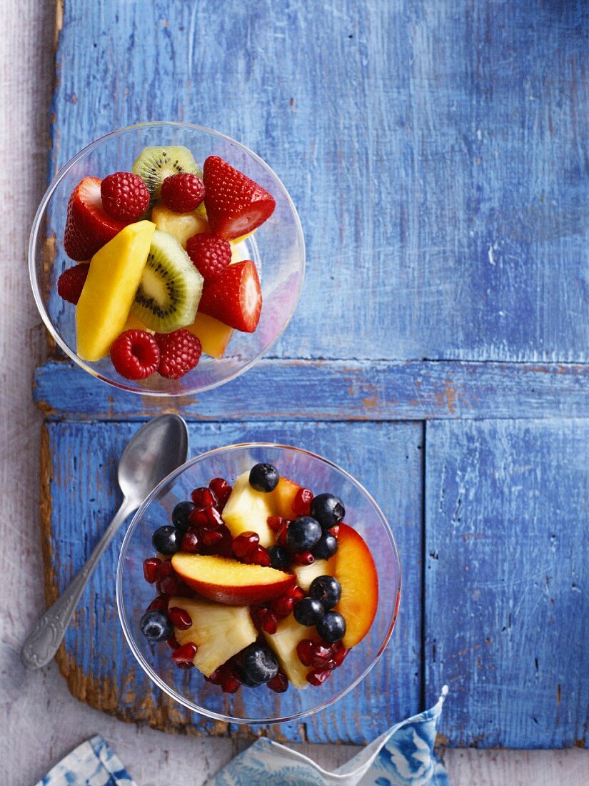 Bowls of fruit salad on wooden board