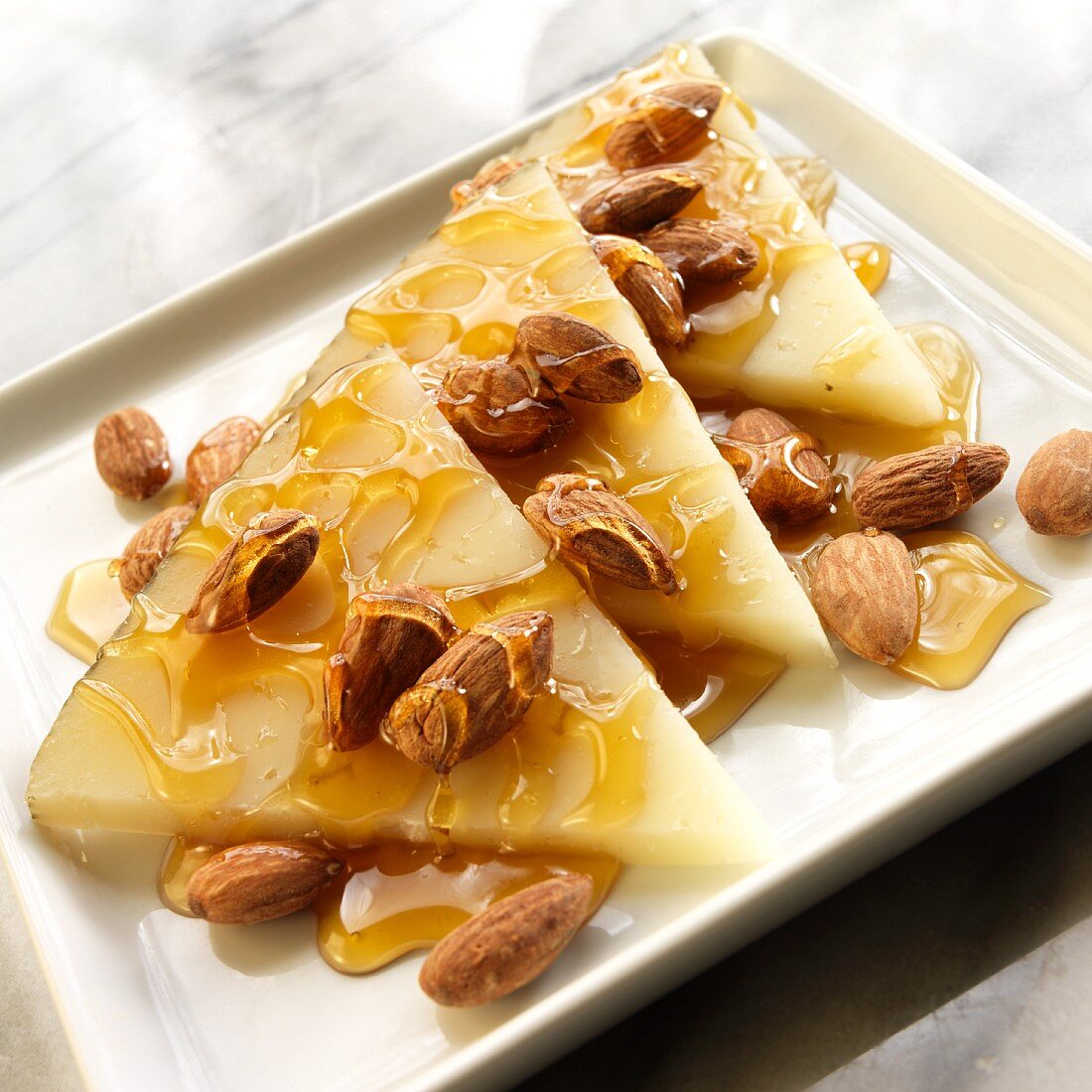Thin Wedges of Manchego Cheese with Roasted Almonds and Honey