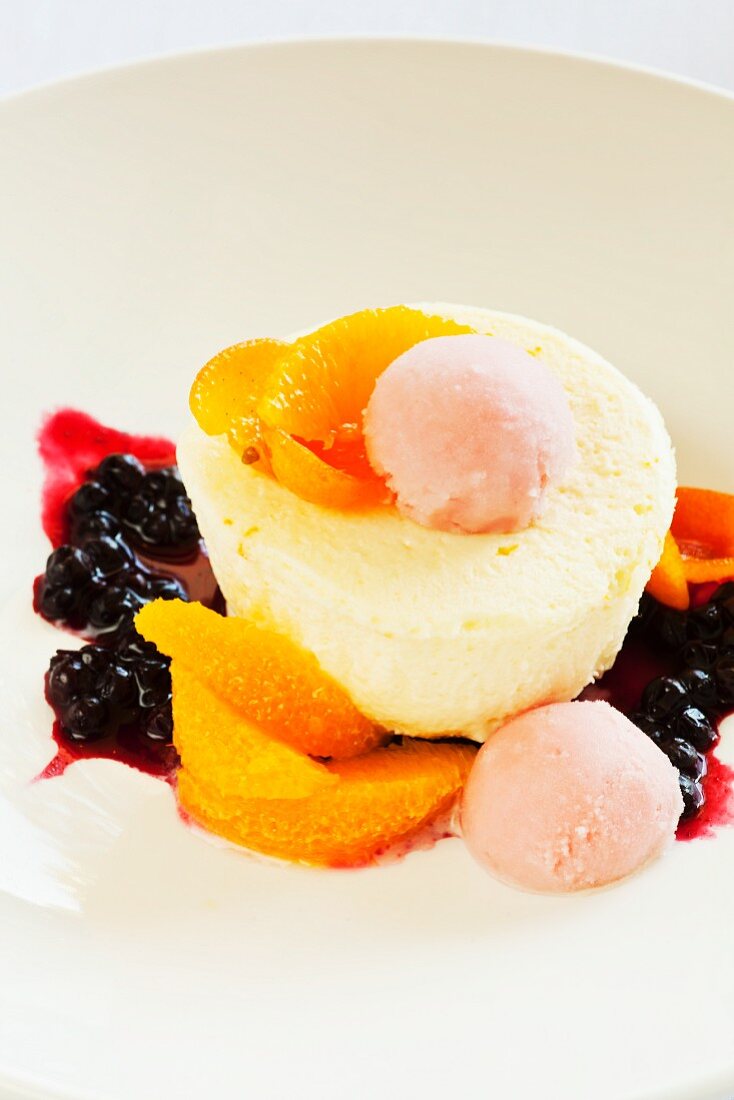 Orangen-Käsekuchen mit Blutorangensorbet und Beerensauce