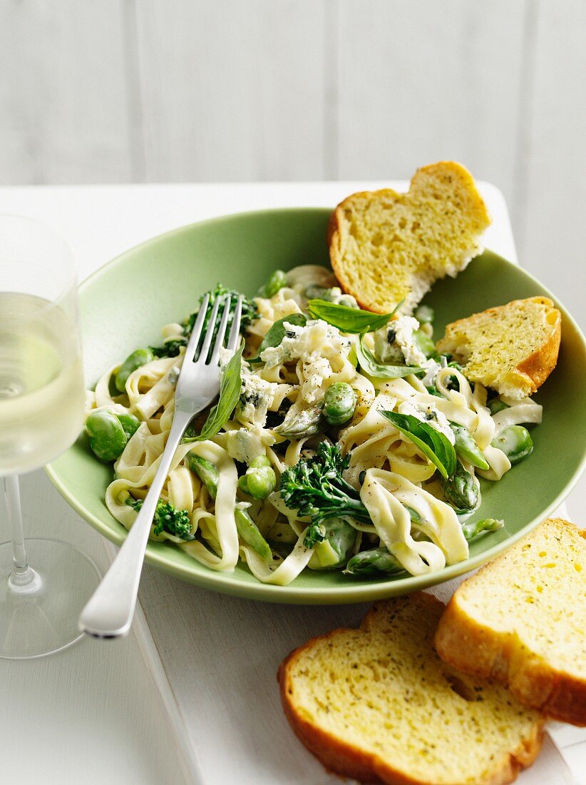 Bowl of pasta with peas and toast