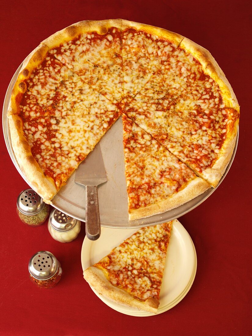 Eine ganze Pizza mit Käse, ein Stück herausgeschnitten