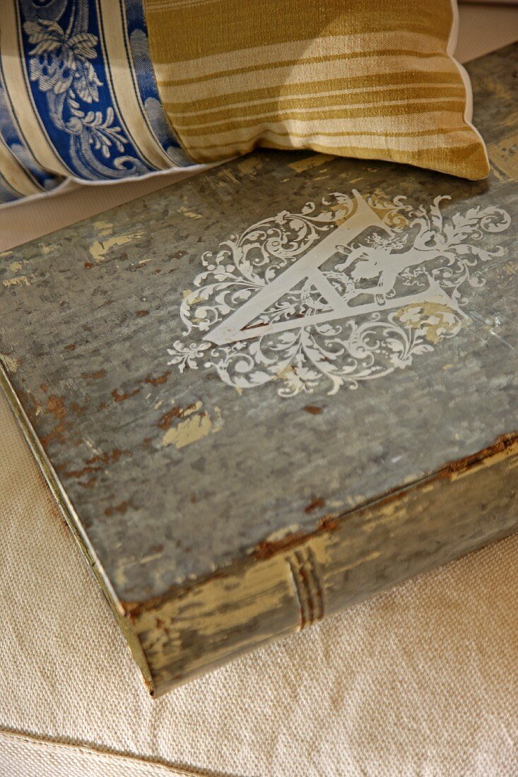 Antiquarian book and vintage cushion on upholstered seat