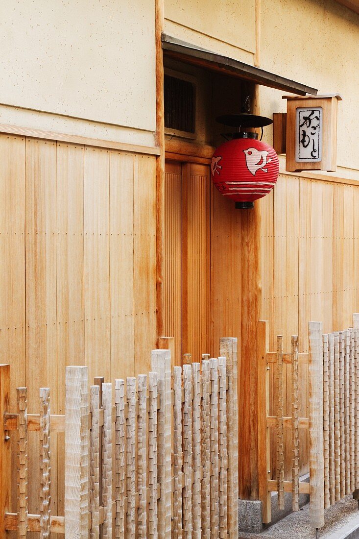 Red Asian Lamp Hanging Outside a Building Door