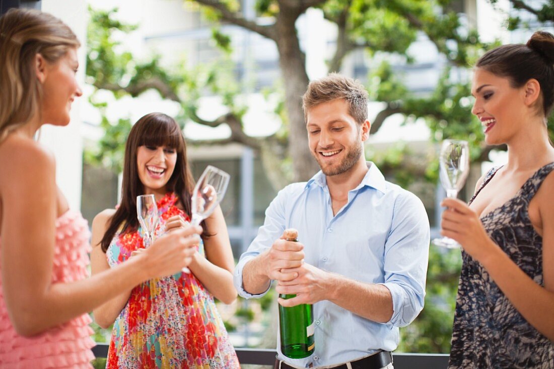 Fröhliche Runde mit Champagnerflasche