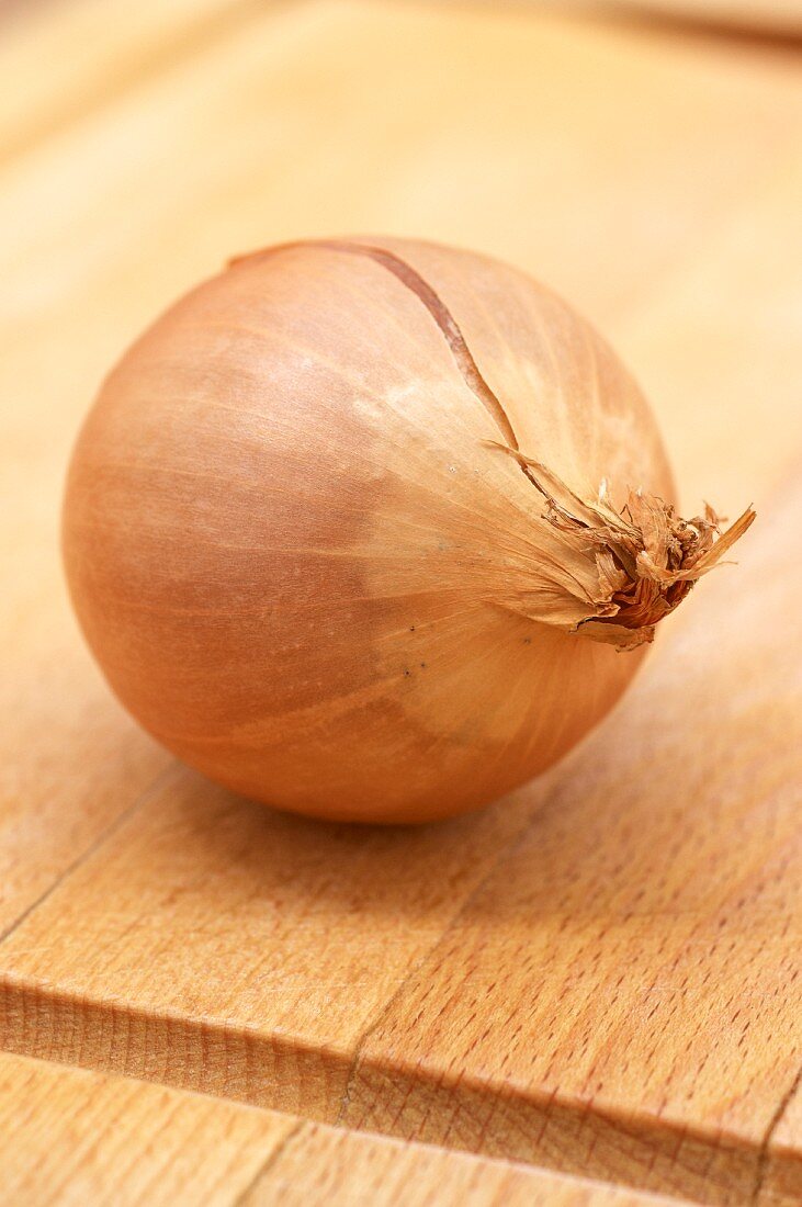 An onion on a wooden chopping board