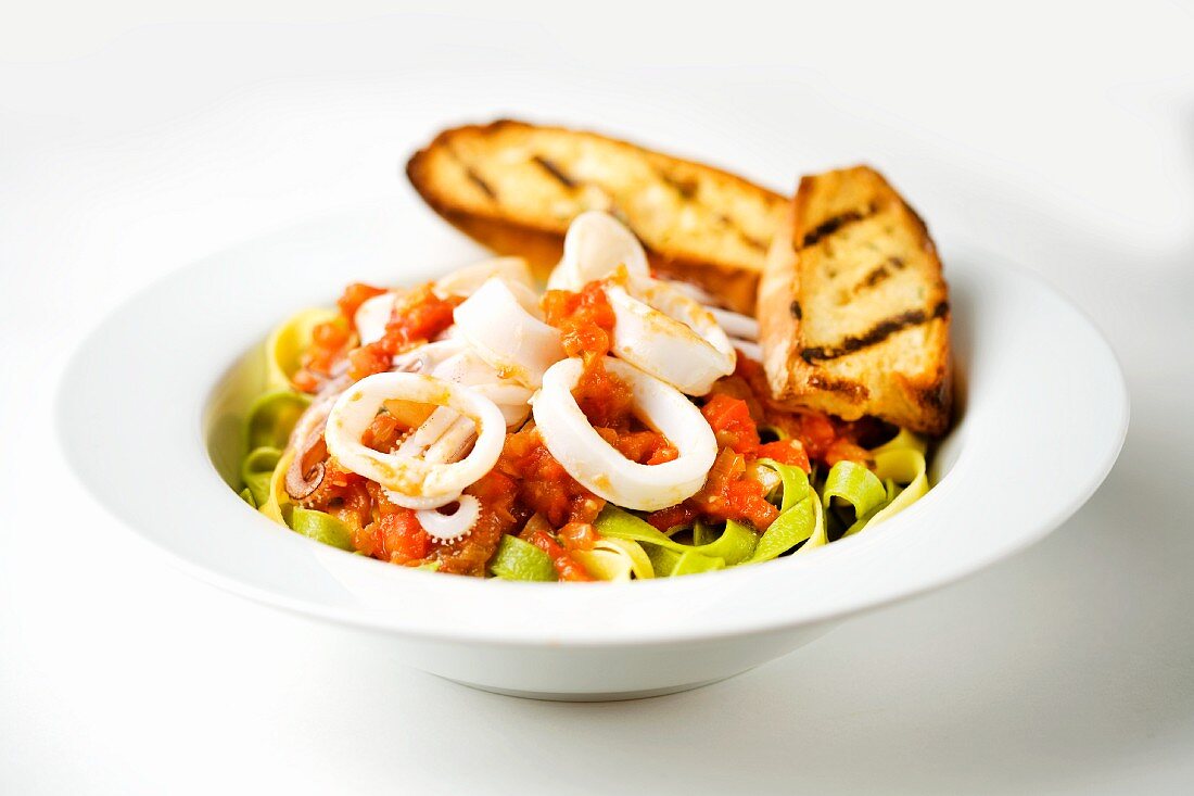 Cold Calamari Salad Over Spinach Noodles with Grilled Bread Slices