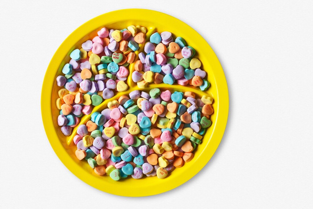 Colorful Conversation Hearts on a Divided Yellow Plate; From Above; White Background