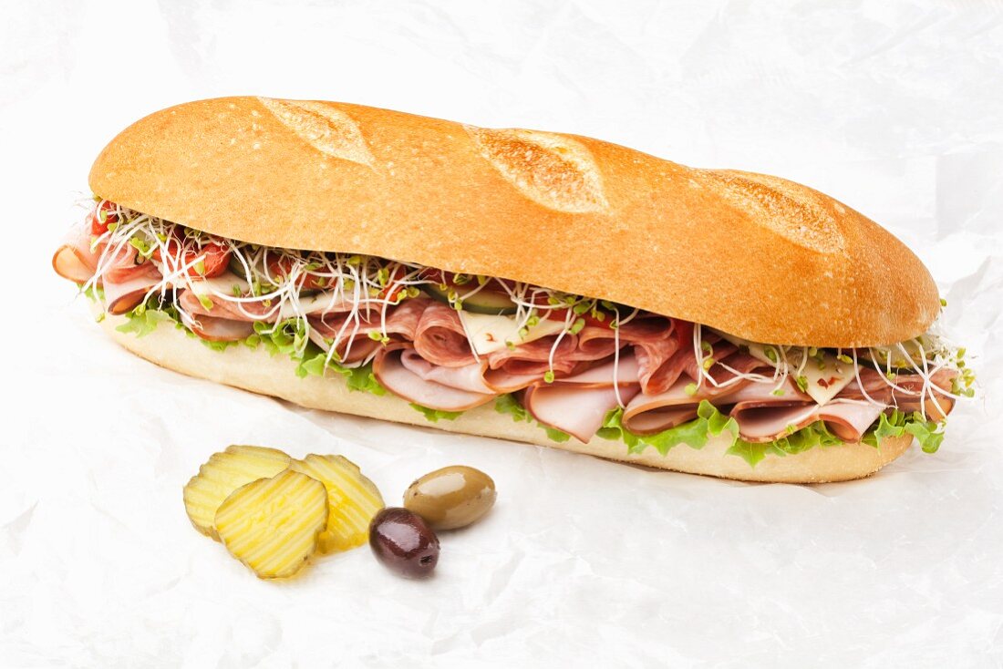 Large Submarine Sandwich with Pickles and Olives; White Background