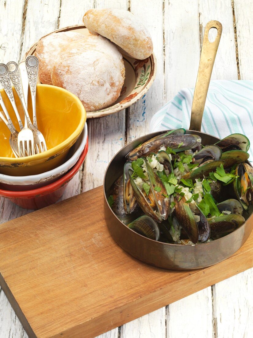 Mussels with herbs and bread in the background