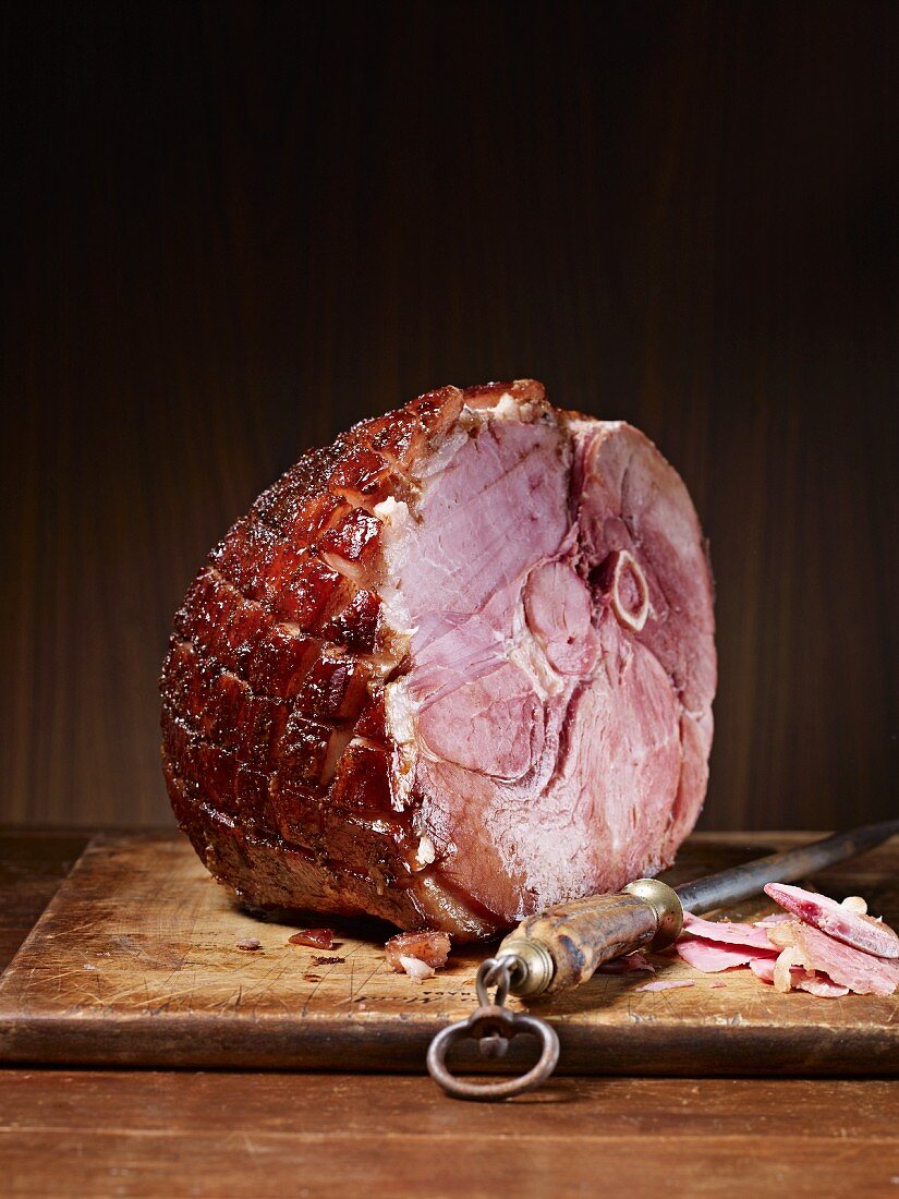 Roast ham with bones on a chopping board