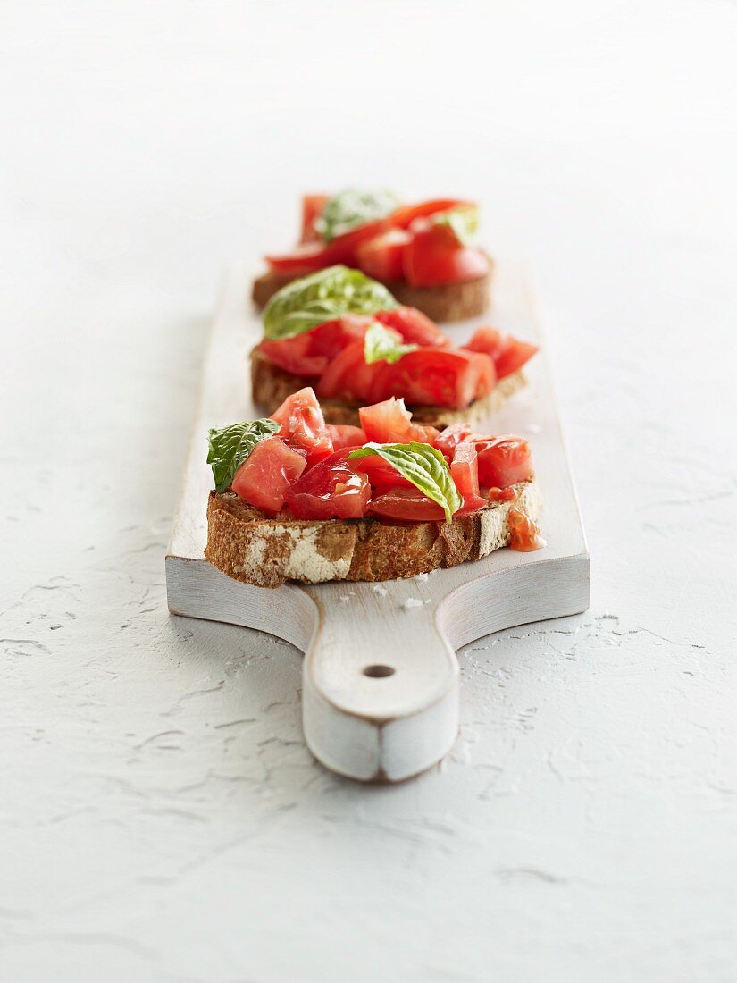 Bruschetta auf einem weissen Holzbrett