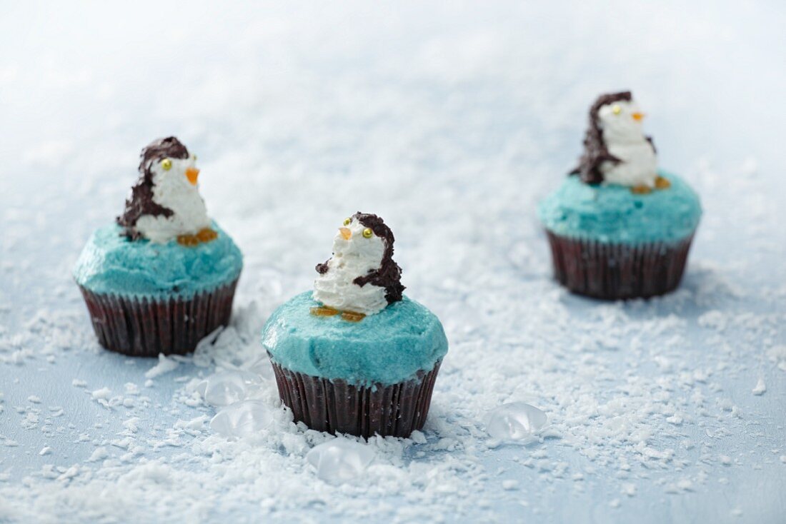 Three cupcakes decorated with penguins