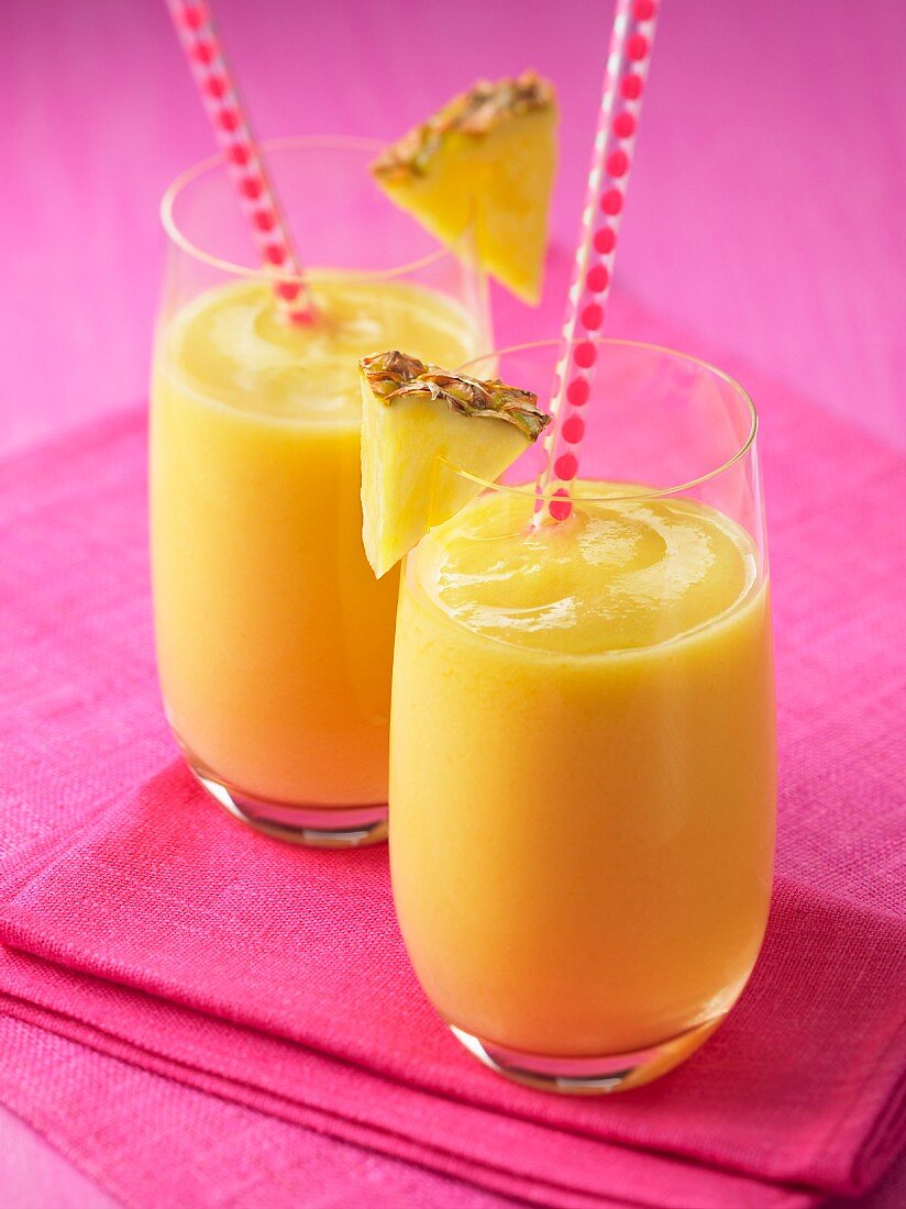 Two glasses of pineapple and mango smoothies