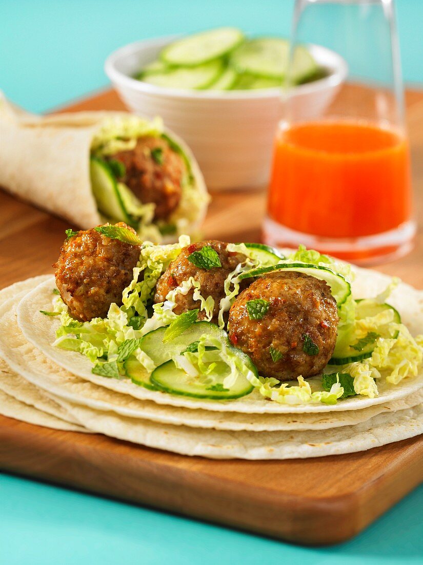 Schweinehackbällchen mit Salat auf Weizentortilla