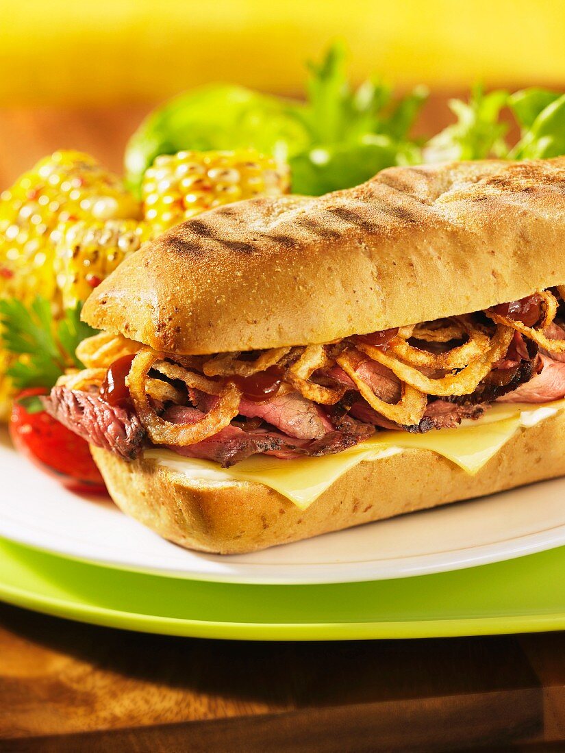 Toasted steak sandwich with onion rings and cheese