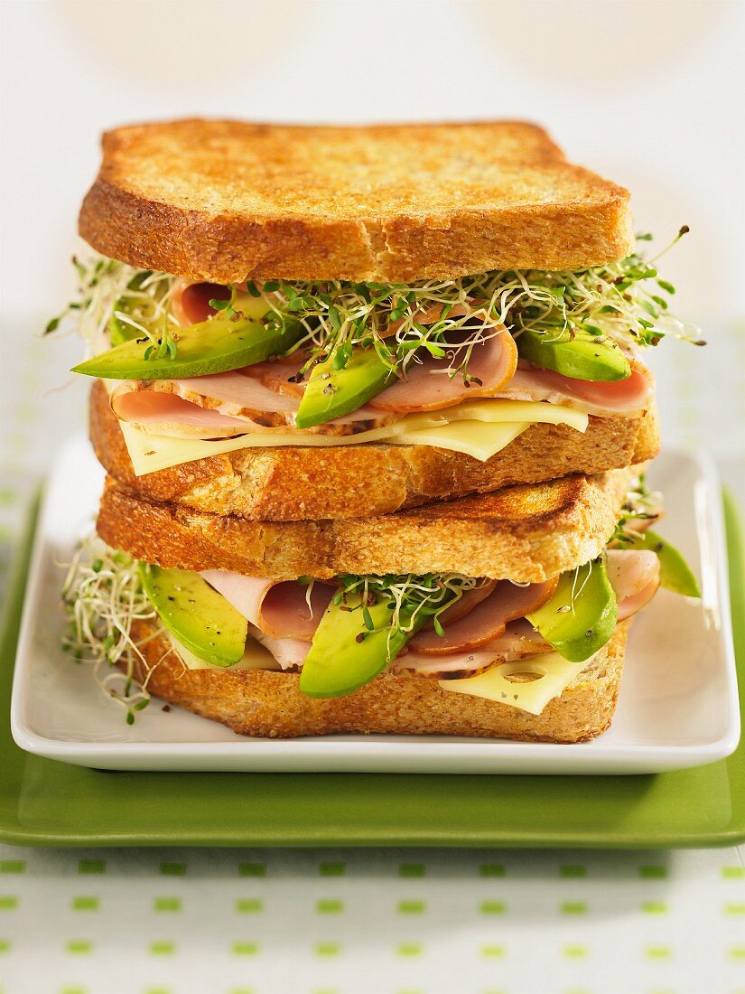 Getoastete Sandwiches mit Käse, Putenschinken, Avocado und Sprossen