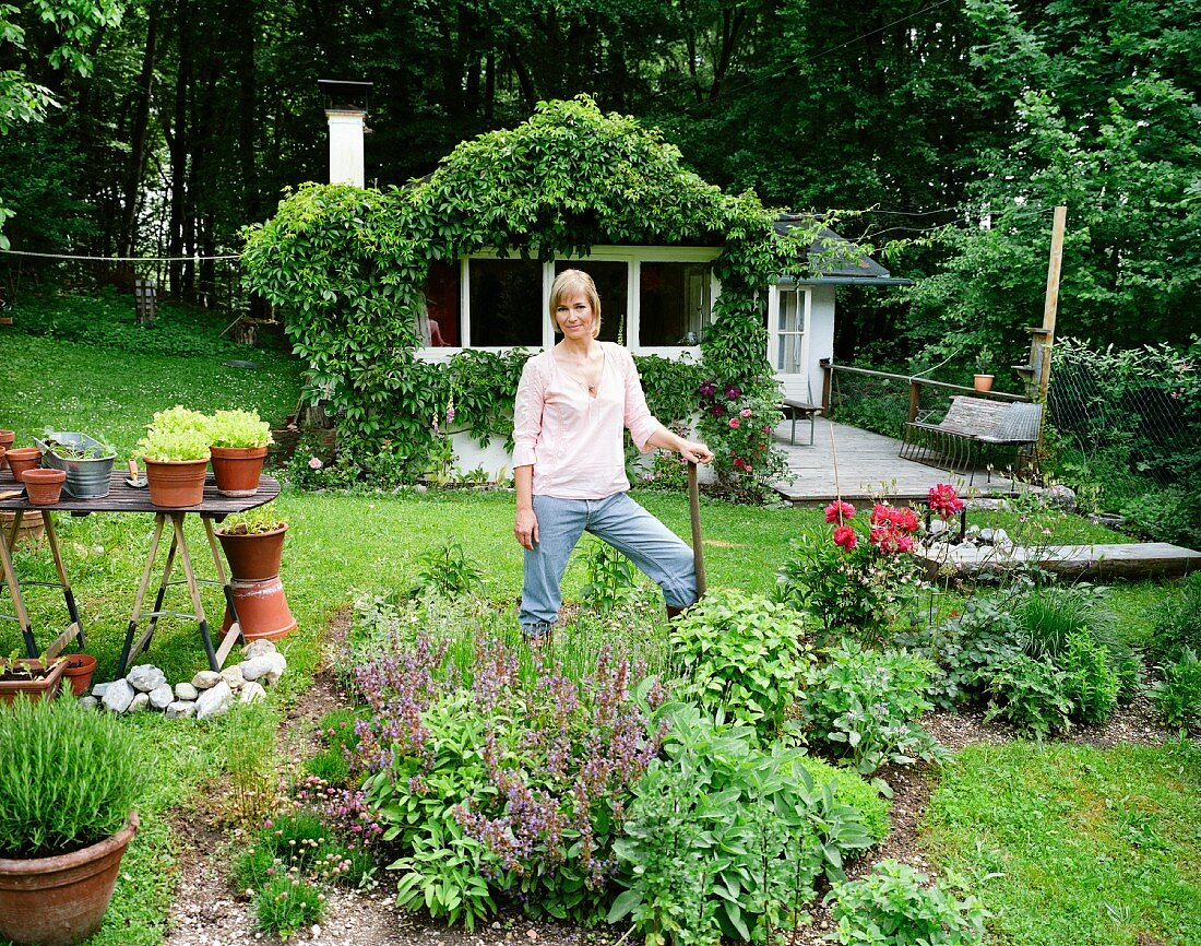 Frau in ihrem Garten mit Gemüse