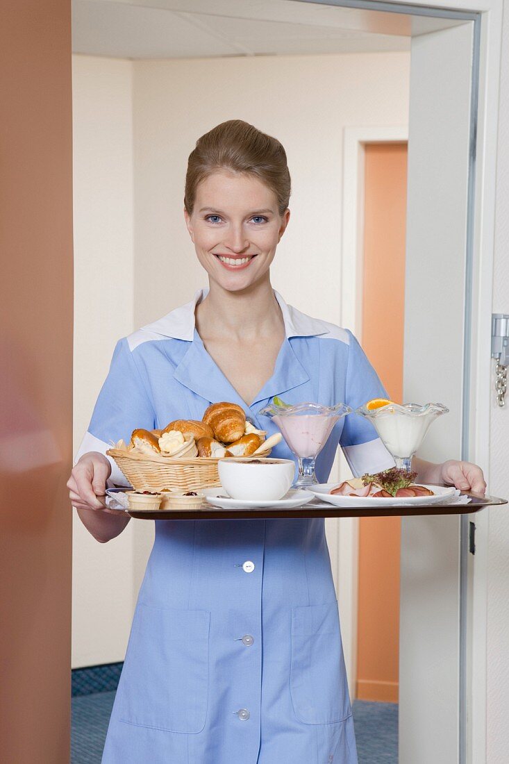 room maid holding tray with breakfast