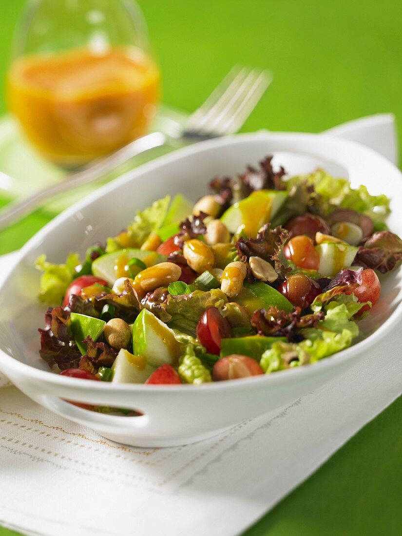 Mixed leaf salad with peanuts, grapes and pears with mango chutney in the background