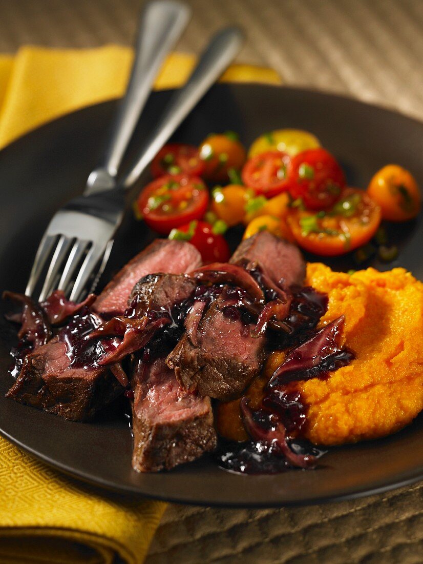 Steak with a red wine-mushroom sauce, pumpkin puree and cocktail tomatoes