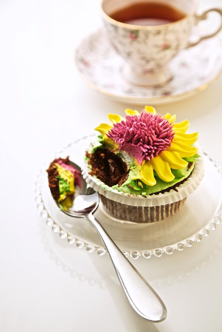 Blumen-Cupcake und eine Tasse Tee