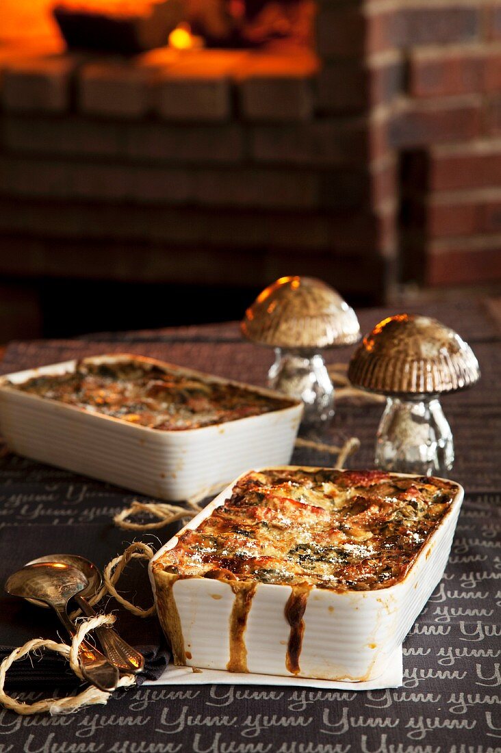 Dishes of mushroom lasagne with an oven in the background